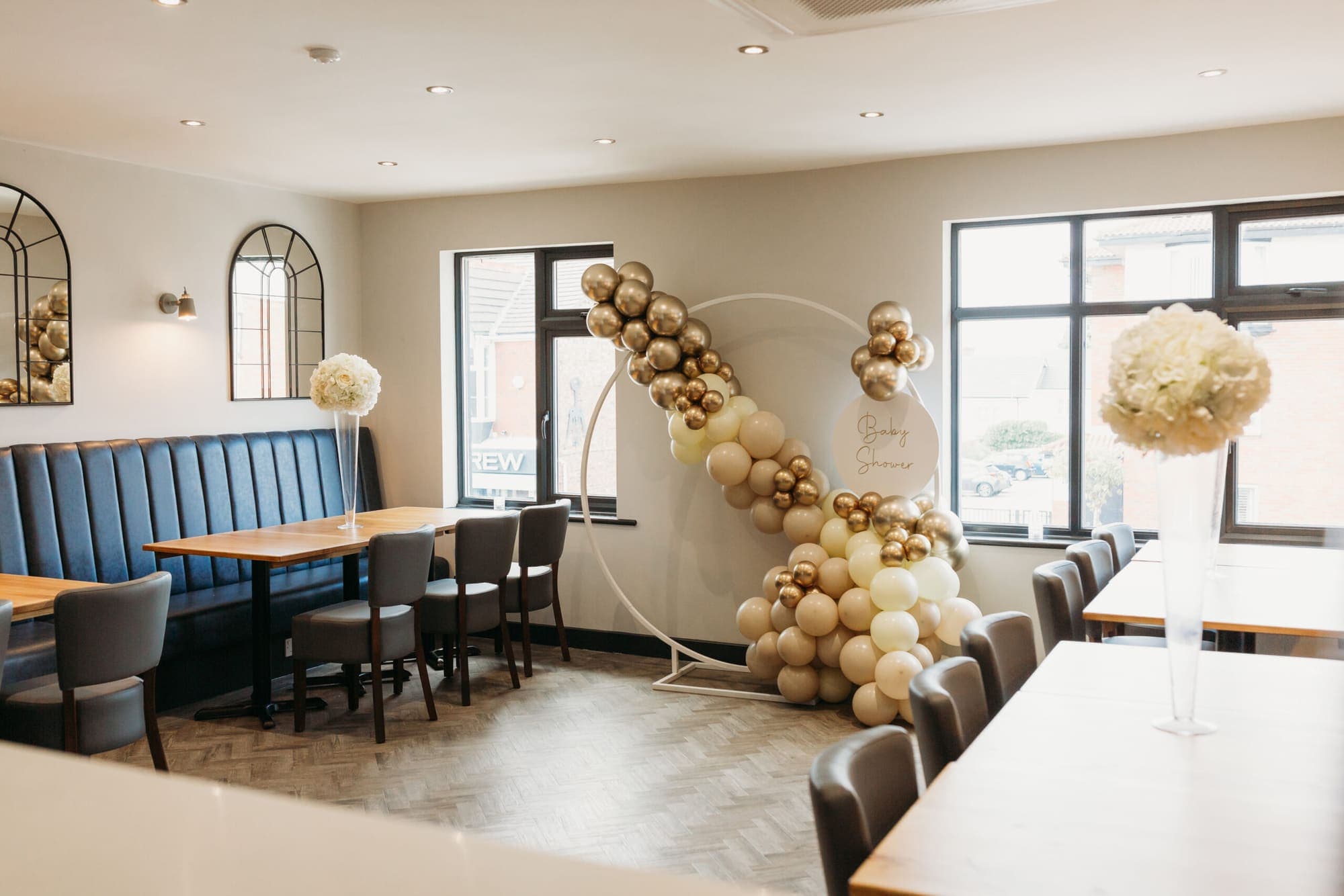 A cream and gold balloon arch set up in the function room for a baby shower