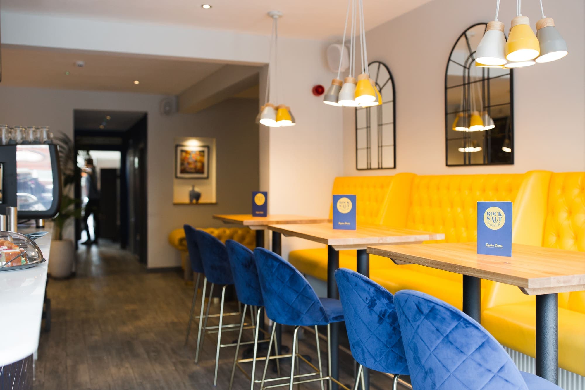 High stools along the bar counter with arched mirrors behind