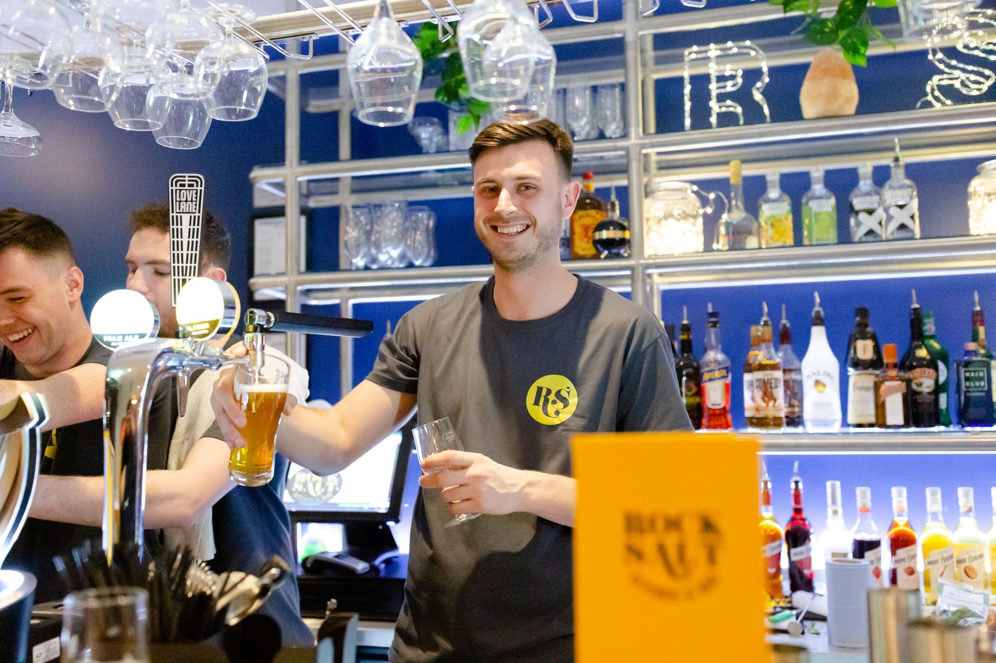 A bartender holding up a freshly poured beer