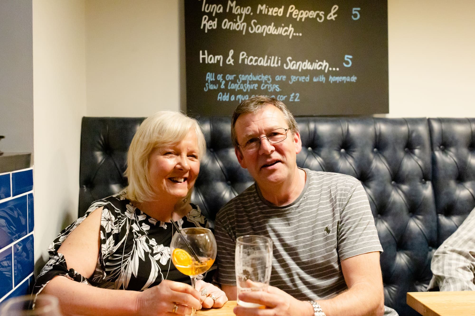 Two guests with drinks at a table in the bar