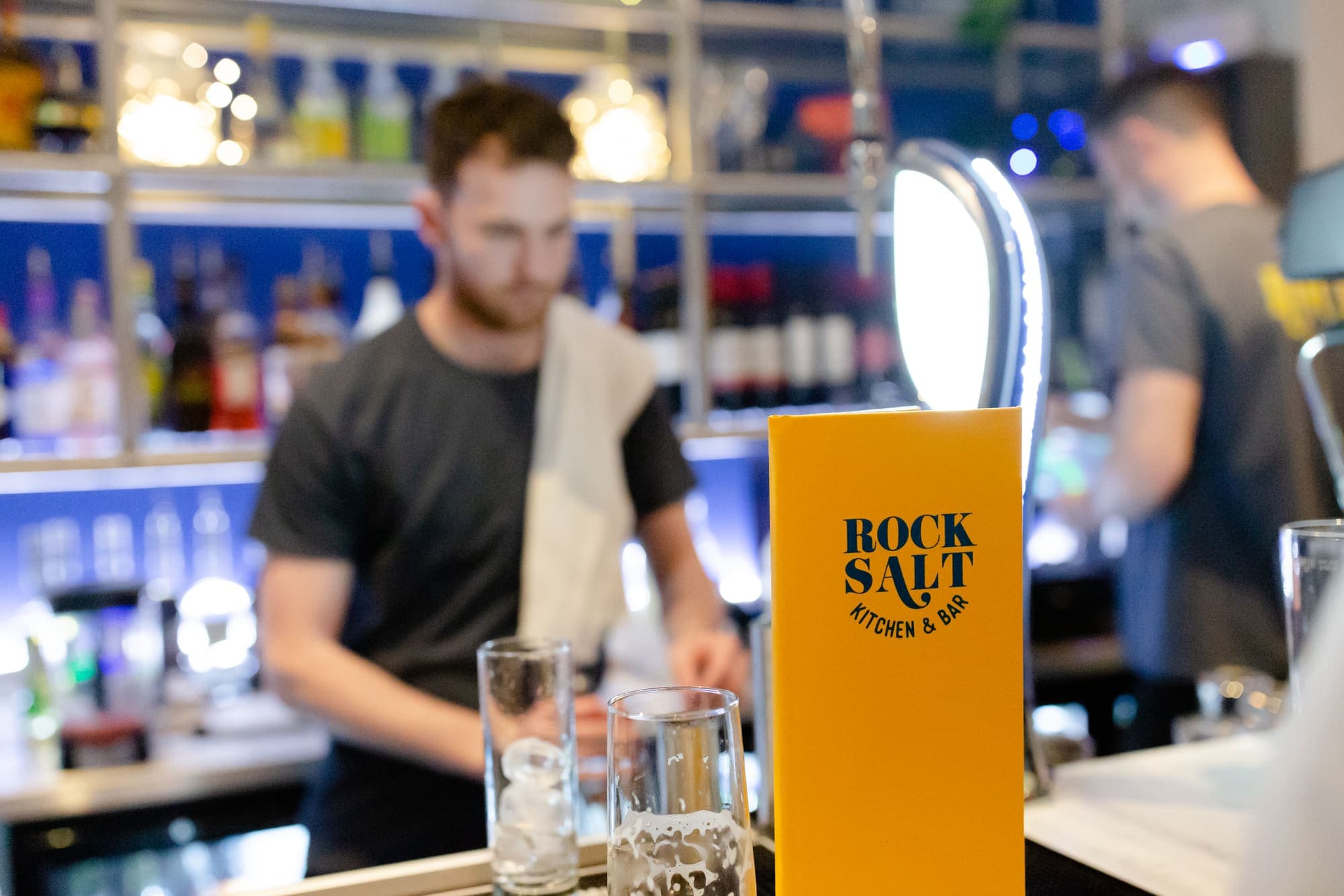 A bartender pulling a pint at the taps
