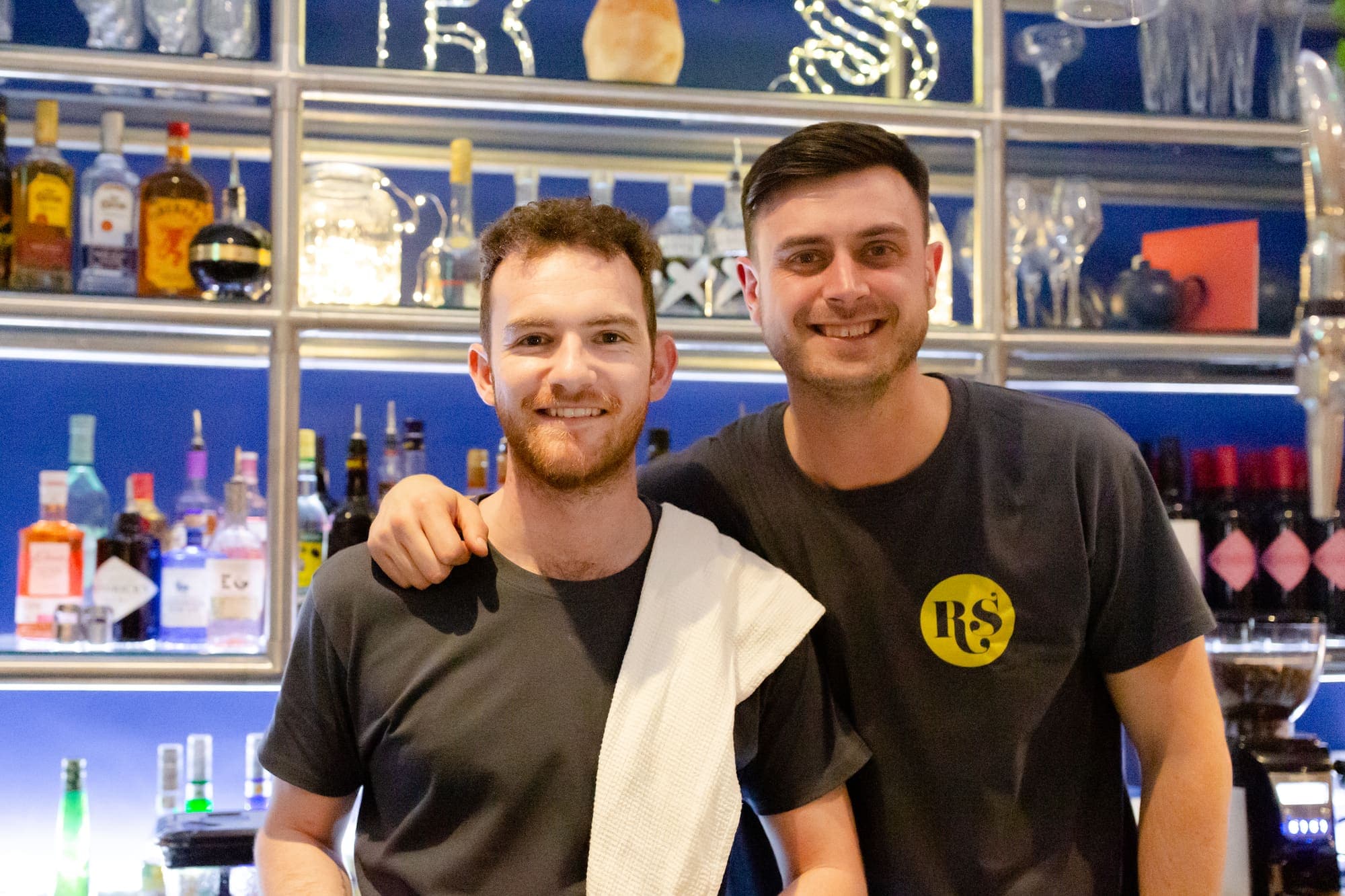 Two members of the bar team behind the back bar