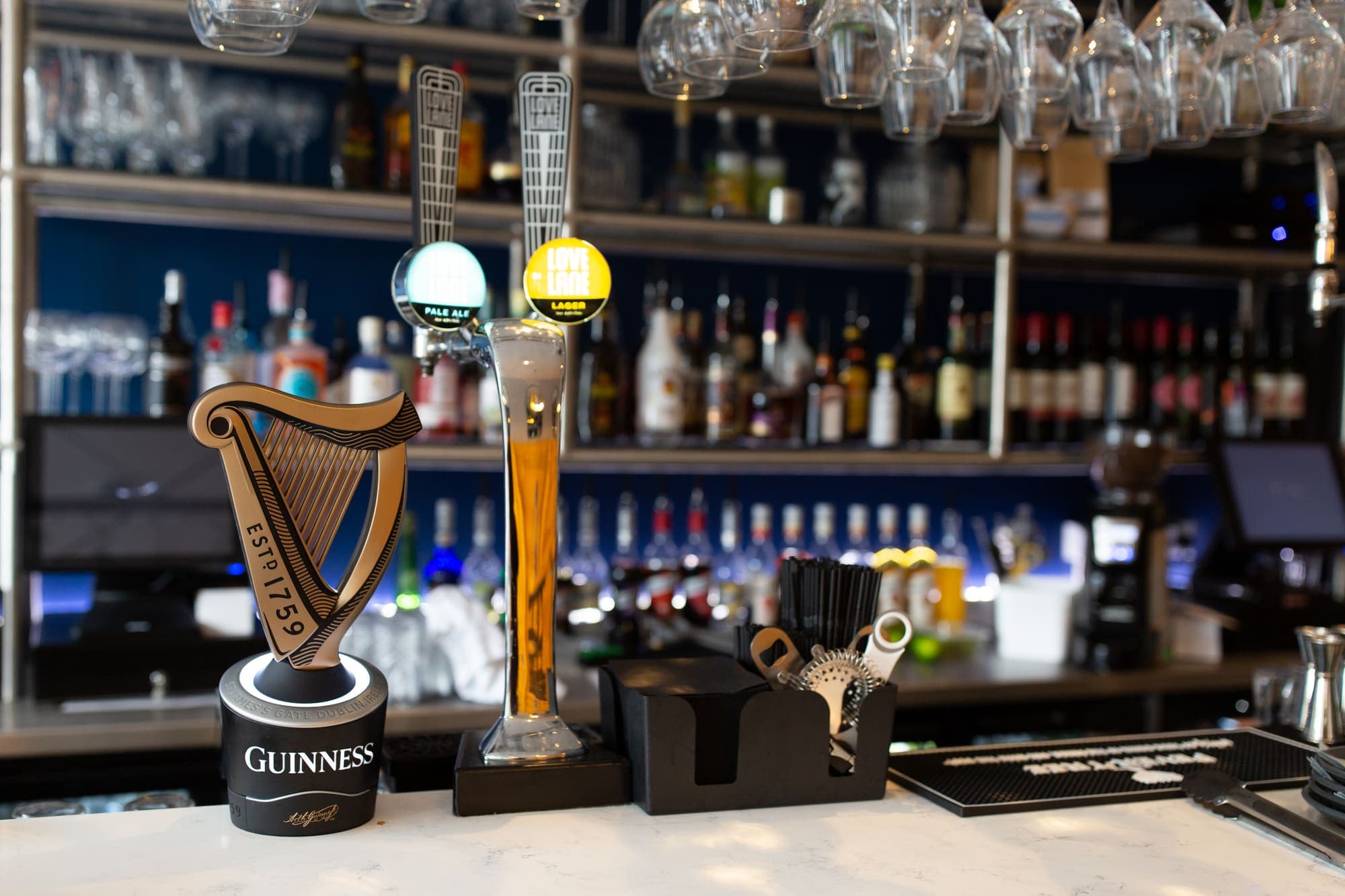 Beer taps at the bar with the back bar's spirits behind