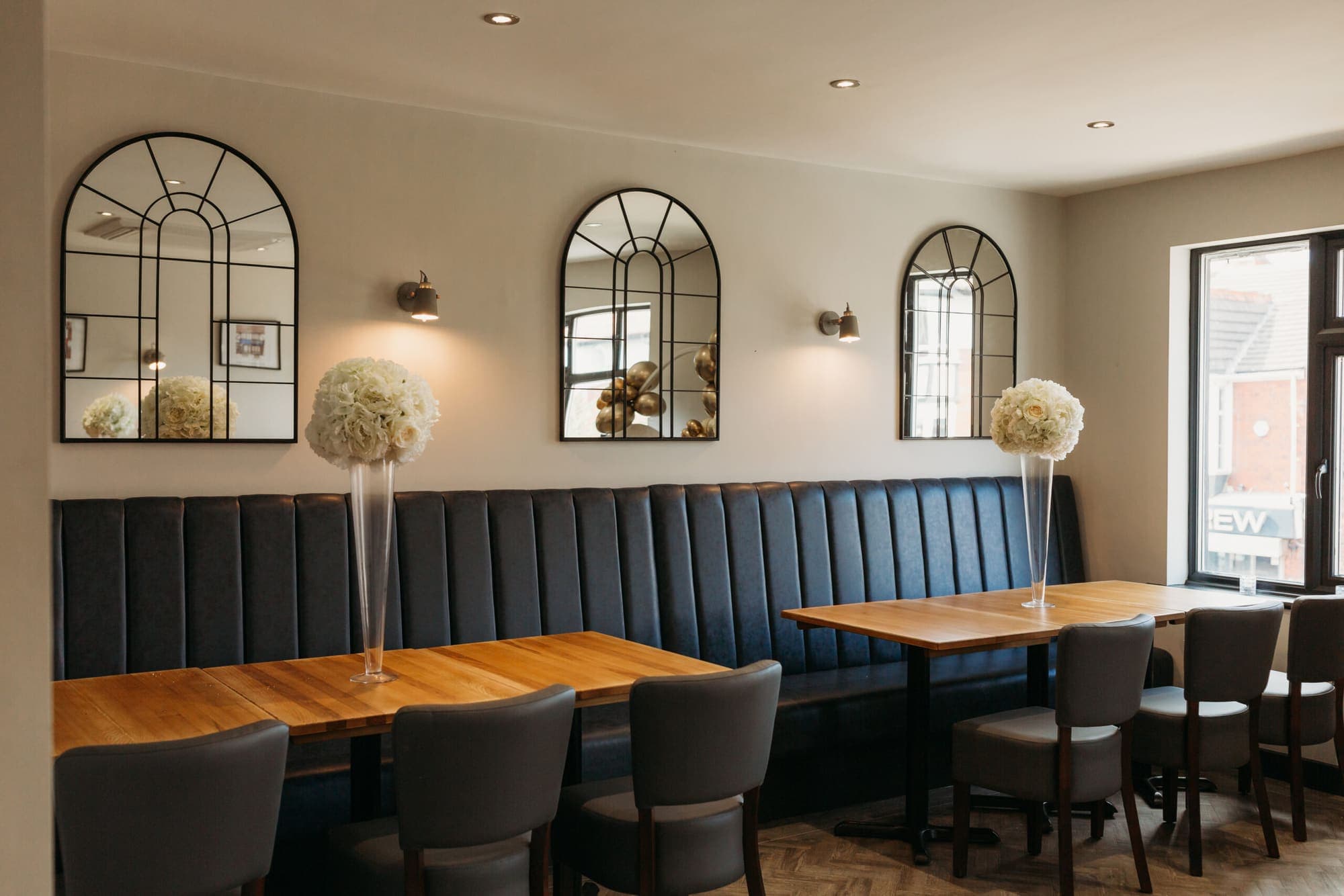 The upstairs function room laid out with tall white floral centrepieces