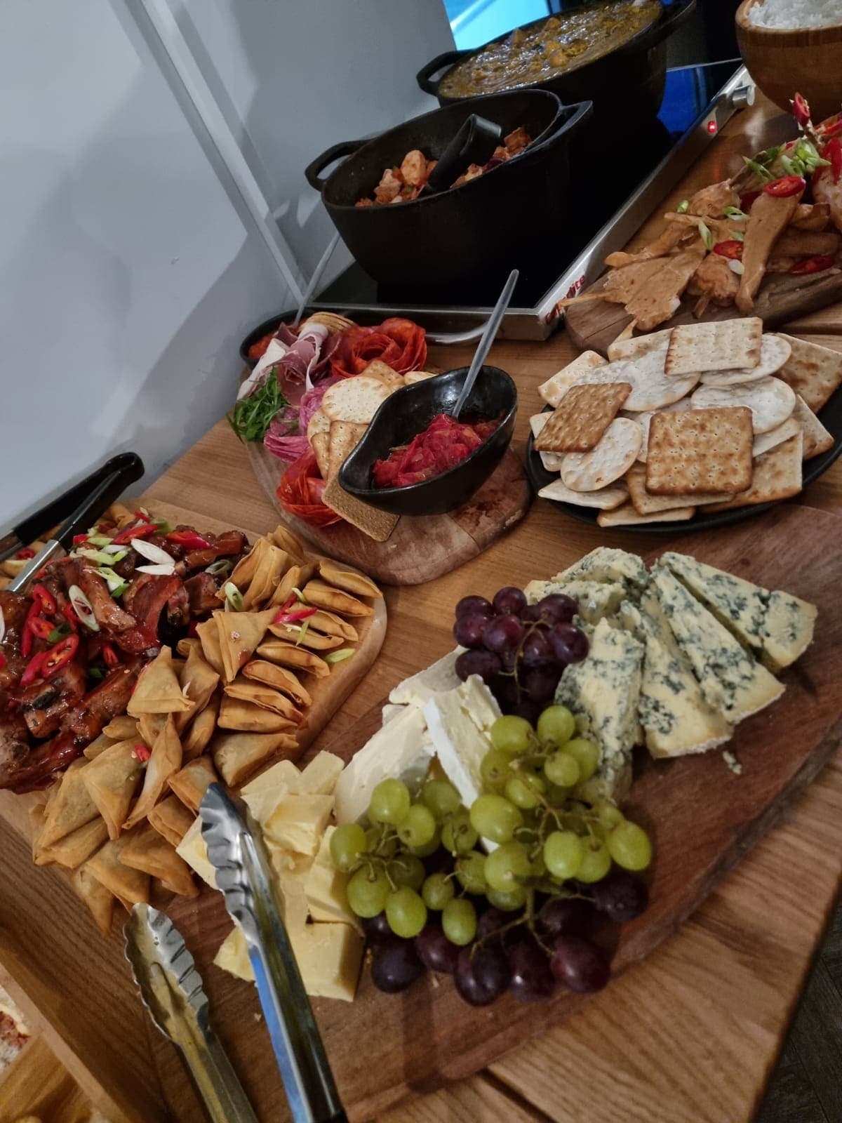 A sharing board of cured meats, blue cheese, crackers, grapes and dips
