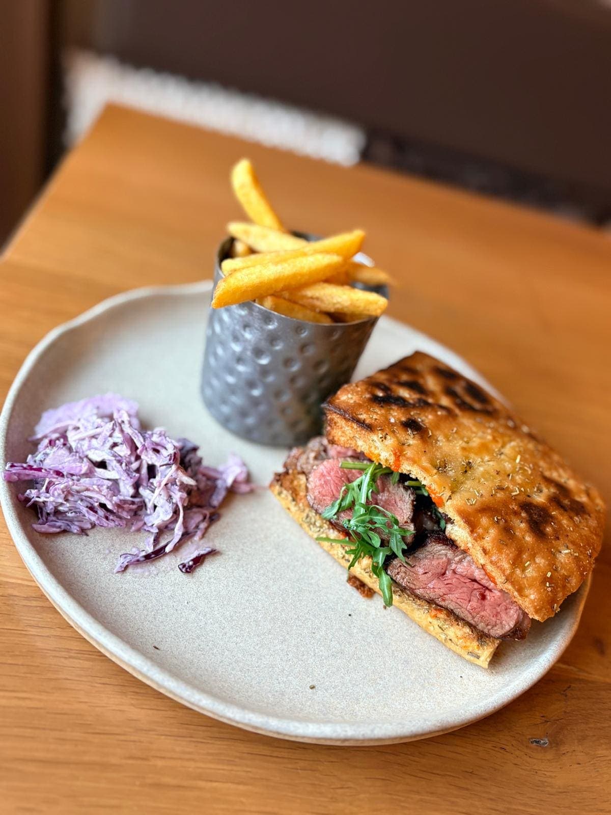 Steak ciabatta served with red cabbage slaw and a cup of fries