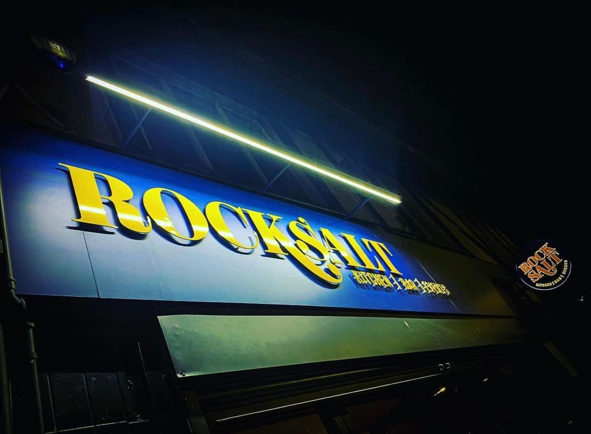 The illuminated Rock Salt sign above the frontage on Coronation Road at night